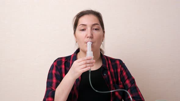 Brunette Woman Breathes Steam Using Oral Nebulizer Tube