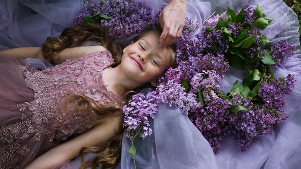 Girl Child in a Magnificent Dress Lies on the Ground