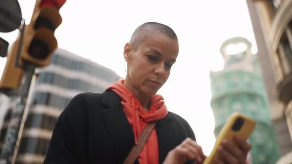 Pensive bald woman looking at the phone