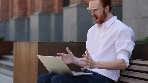 Loss Man Frustrated By Results on Laptop While Sitting on Bench