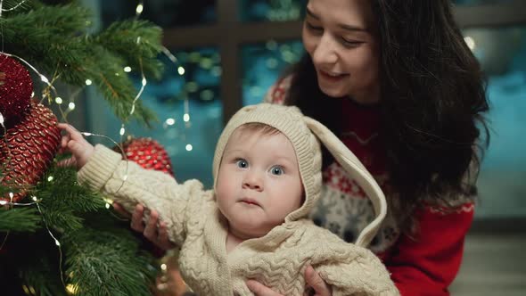 Baby Looks at Toys on Christmas Tree Xmas