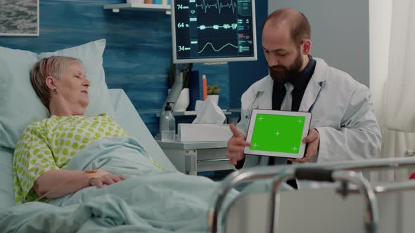 Doctor Holding Horizontal Green Screen on Digital Tablet