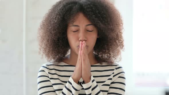 Hopeful African Woman Praying with Hands Crossed 