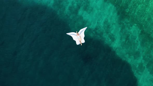 The girl is swimming in the sea. View from the air. Vacation and relaxation.