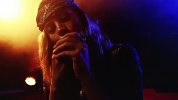 Woman playing harmonica at nightclub