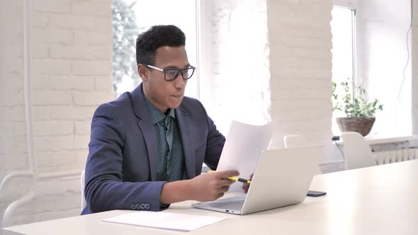 Businessman Celebrating Success While Reading Documents in Office