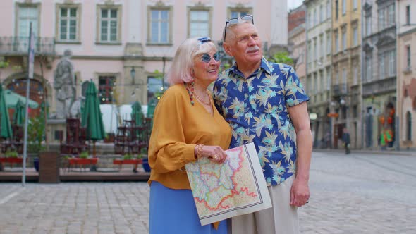 Elderly Stylish Tourists Man Woman Enjoying Conversation on Street Holding Paper Map in Old Town