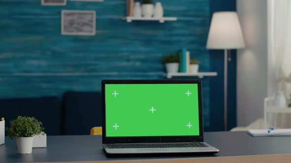 Laptop Display with Green Screen Background on Desk