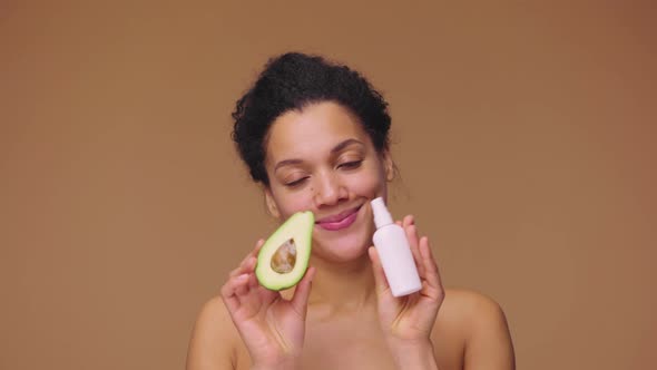 Beauty Portrait Young African American Woman Holding Half an Avocado and Face Cream Natural Skin