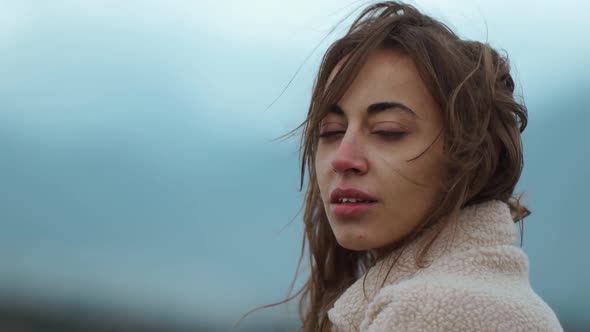 Close Up Portrait of Freezing Ukrainian Woman in Civil Cloth Stands Outdoors at Cold Windy Cloudy