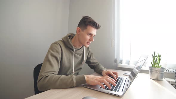 Young Businessman Works on Laptop