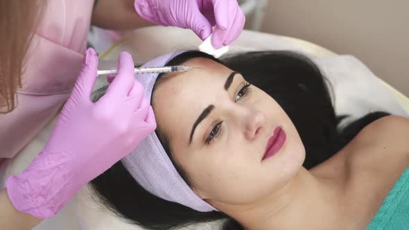 A woman on the procedure of injections in a cosmetology clinic