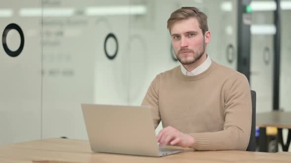 Creative Young Man Showing No Sign By Sign While Working on Laptop