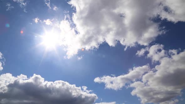 Time lapse: tense fluffy clouds cover the sun. Sun rays brake through clouds.