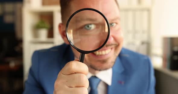 Portrait of Young Smiling Businessman Looking Through Magnifying Glass Slow Motion  Movie