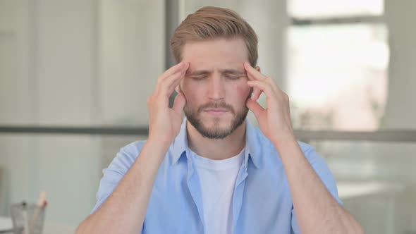 Portrait of Young Creative Man Having Headache