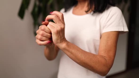 Slow Motion Mature Woman Applying Moisturizing Hand Cream at Home