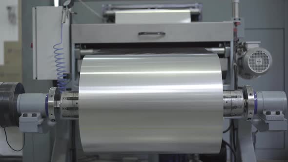 Big Roll of Aluminium Foil Sheet Rolling on Industrial Machinery. Equipment Working in Factory