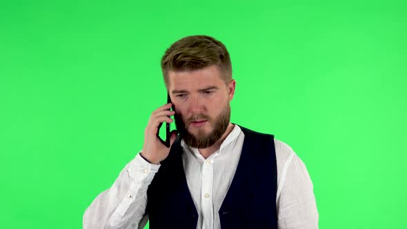 Man Angrily Speaks on the Phone, Proves Something on Green Screen.