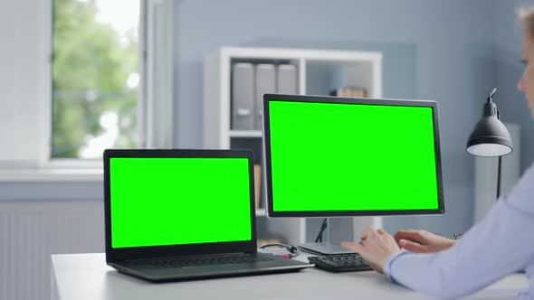 Woman Working on Two Computers