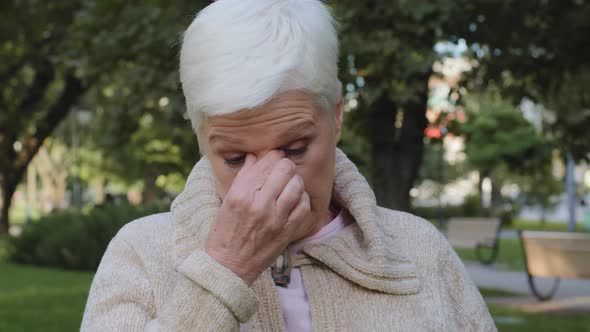 Closeup of Middleaged Woman Reduces Eye Strain Closed Eyes Touch Rubs Nose Bridge Sad Elderly