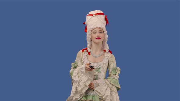 Portrait of Courtier Lady in White Vintage Dress and Wig Watching TV and Changing Channels Using