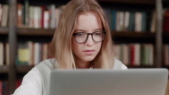 Close Up Young Teen Blonde Girl in Glasses Working on Computer at School Library