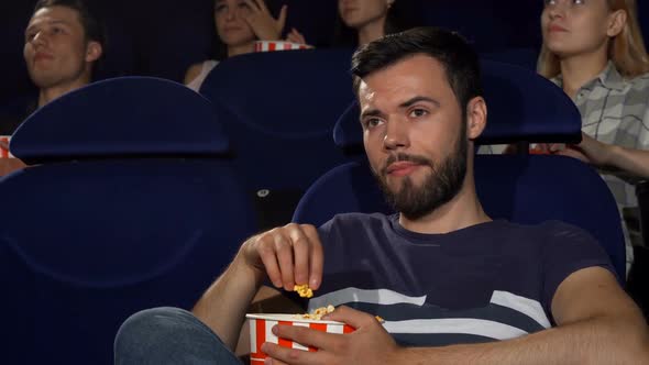 Attractive Young Man Eating Popcorn During Boring Movie at the Cinema 1080p