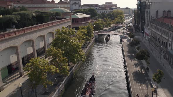 Aerial pull out shot capturing sightseeing moliceiro boats and Art Nouveau buildings