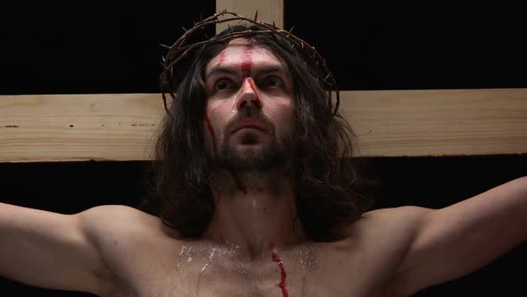 Sacrificing Messiah in Crown of Thorns Looking Camera, Tears and Blood on Body
