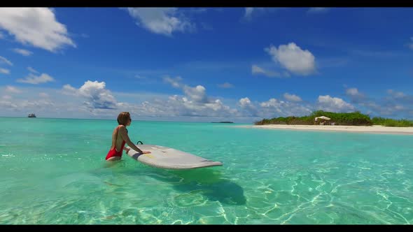 Teenage lovers sunbathing on exotic tourist beach voyage by blue sea and white sandy background of t