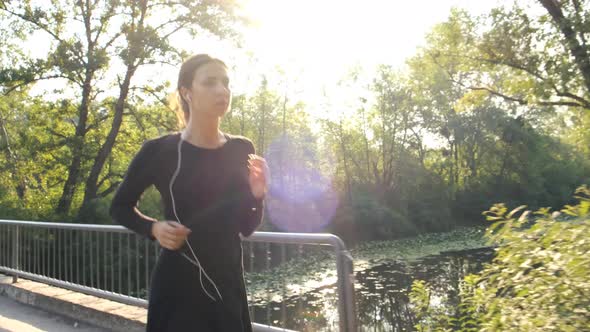 Woman Jogging in Park Outdoors. Fitness Girl Runs in the Morning During the Sunrise