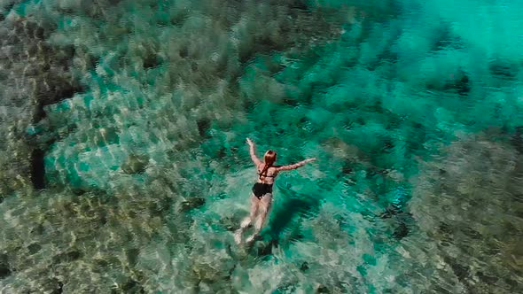 Young Woman Swimming in Sea Near Beach Relaxing in Blue Water