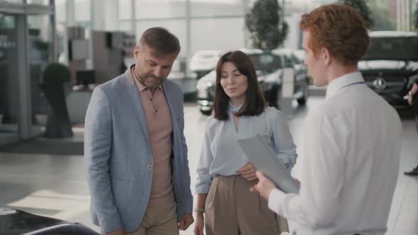 Man Shaking Hand of Car Salesman in Dealership