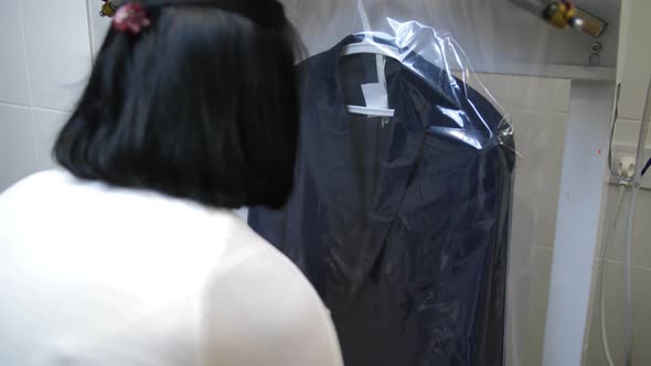 Worker's Hands Putting Packaging on Cleaned Suit