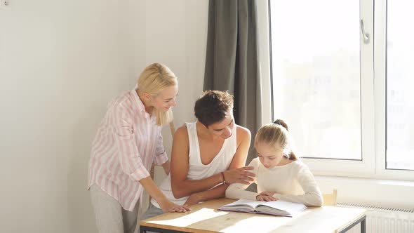 Young Parents Help Their Daughter Do Their Homework