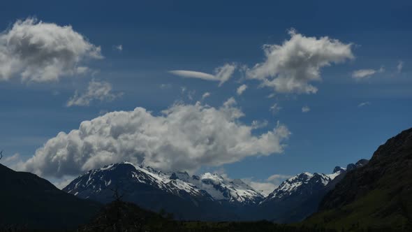 Time lapse view of clouds in blue sky over majestic mountains
