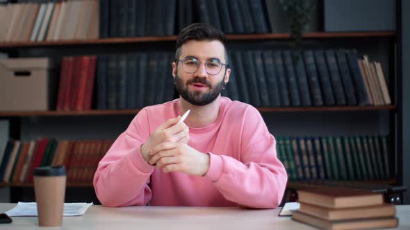Smiling Latino Bearded Man Blogger Talking Business Educational Information at Library Desk