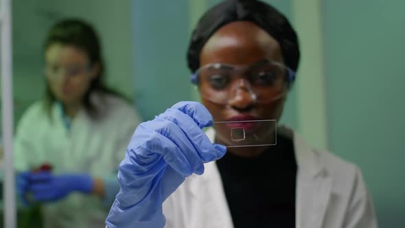 African Botanist Woman Looking at Genetic Test Sample for Biological Experiment