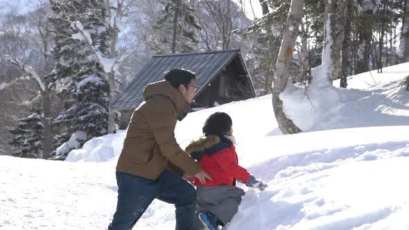 Asian Father And Son Playing In The Park On Winter Day 