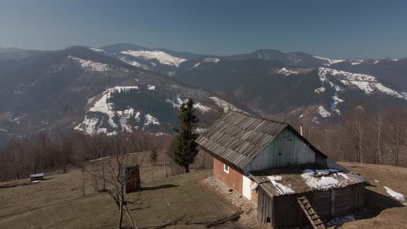 Village House on a Background of Winter Mountains