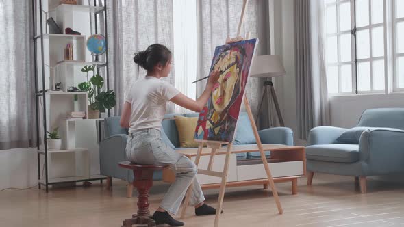 Asian Artist Girl Coming To Sit And Holding Paintbrush Painting A Girl's Hair On The Canvas