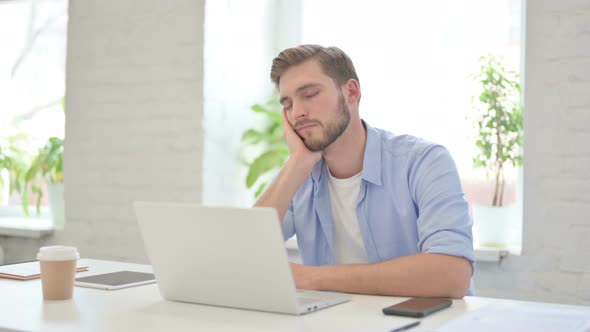 Young Creative Man Taking Nap While Sitting in Modern Office