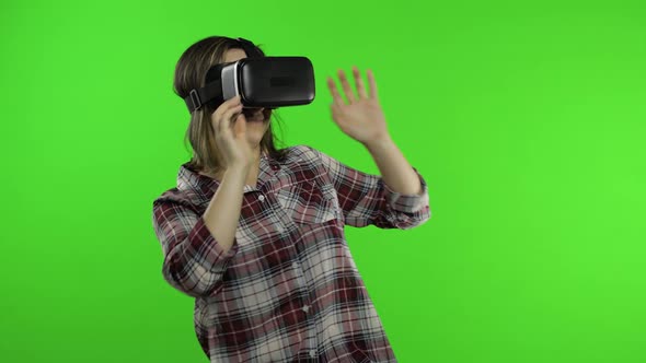 Girl Using VR App Helmet To Play Simulation Scary Game. Woman Watching Virtual Reality 3D Video