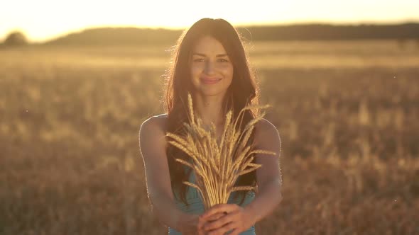 Lovely Girl Holding Ripened Wheat Ears on Field