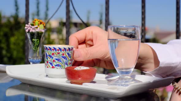 Contented Woman Tastes Delicious Mug of Turkish Coffee on Veranda in Lovely Midsummer Weather