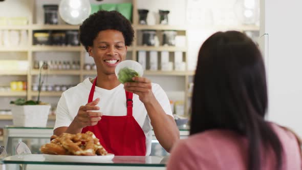 Animation of happy biracial waiter selling food to female customer