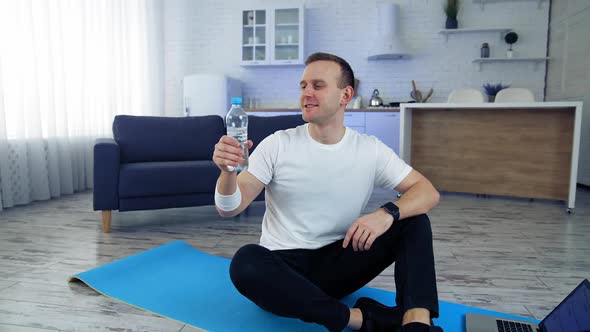 Young man practicing fitness with online training on laptop