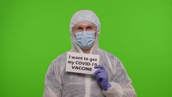 Doctor in Suit with Syringe Ampoule and Text Slogan on Paper  I Wand To Get My Covid19 Vaccine