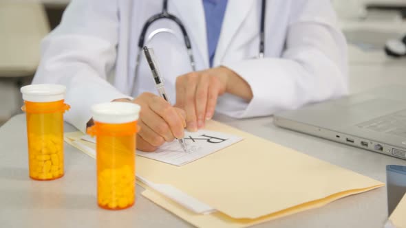 Doctor writing a prescription at desk